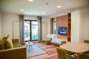 a living room with a table and a couch at Royal Maison Apartments in Cluj-Napoca