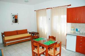 a kitchen with a table and a couch in a room at Giorgos Apartments in Palaiochora
