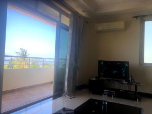 sala de estar con ventana grande y TV en Bay's view, en Dar es Salaam
