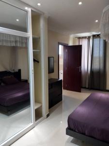 1 dormitorio con cama morada y espejo en Bay's view, en Dar es Salaam