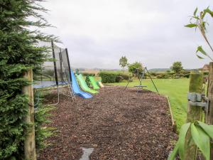 a playground with a bunch of swings in a yard at 3 Old Orchard in Much Wenlock +7 photos