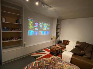 a living room with a couch and a large screen at Beach & Mountain Retreat within a UNESCO Biosphere in Rooiels