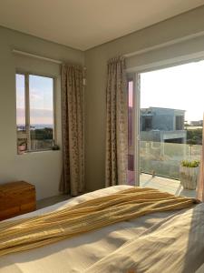a bedroom with a bed and a large window at Beach & Mountain Retreat within a UNESCO Biosphere in Rooiels +63 photos