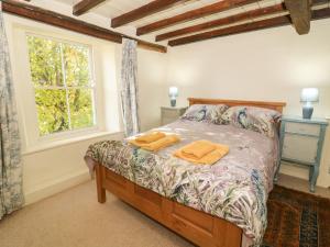 a bedroom with a bed with two towels on it at The Old Post Office in Ampleforth