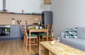 una cucina e un soggiorno con tavolo e divano di City and Thermal Apartman a Győr