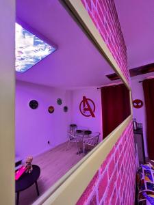 a room with a pink brick wall and a table at Le Marvel - AVENGERS in Bédarieux