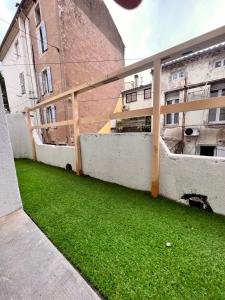 a yard with green grass in front of a building at Le Marvel - AVENGERS in Bédarieux