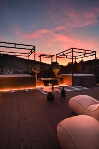 - un toit-terrasse avec des tables et des chaises au coucher du soleil dans l'établissement Graal resort, à Bukovel