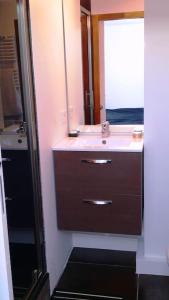 La salle de bains est pourvue d'un lavabo et d'un miroir. dans l'établissement T2 à Anglet grande terrasse vue mer, plage à pied., à Anglet