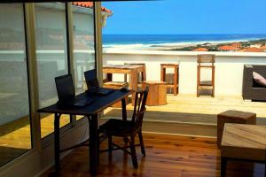 - une table avec ordinateur portable sur le balcon dans l'établissement T2 à Anglet grande terrasse vue mer, plage à pied., à Anglet