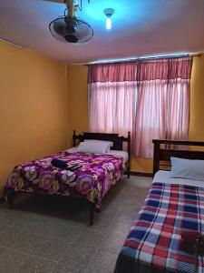 1 dormitorio con 2 camas y ventana en Hotel Berlín, en Guayaquil