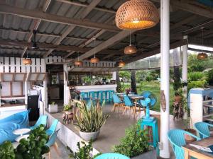eine Terrasse mit blauen Stühlen und Tischen sowie eine Bar in der Unterkunft Le Petit Saint Tropez in Khanom