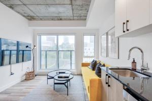 a living room with a yellow couch and a table at INITIAL / Parisianer / Centre-ville de Québec in Quebec City