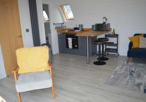 a living room with a table and a yellow chair at Goat Hill Lodge in Broome