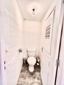 a white toilet in a bathroom with a door at Villa 2 chambres Netflix - Wifi - Parking - Terasse in Ruelle-sur-Touvre