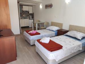 Zimmer mit 3 Betten und einer Küche mit einem Tisch in der Unterkunft Green Paradise in Dugobabe