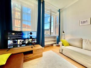 uma sala de estar com uma televisão grande e um sofá em ROYAL 2 Old Town fast WiFi Netflix HBO AppleTV+ em Varsóvia