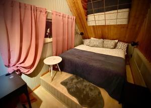 a small bedroom with a bed and a table at Amazing little house on an island with garden in Riga