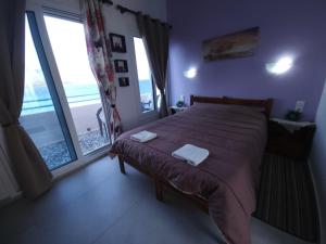 a bedroom with a bed with a view of the ocean at Anna Studios in Myrties