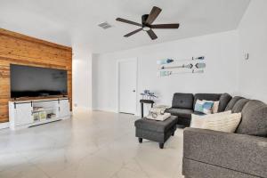 a living room with a couch and a flat screen tv at NEW! 3b/2ba: pool, hot tub, and cotton candy maker in Fort Lauderdale