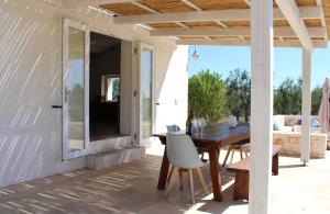 a patio with a wooden table and chairs on a house at Trullo Davide in Martina Franca