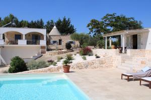 a villa with a swimming pool and a house at Trullo Davide in Martina Franca