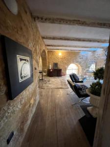 un soggiorno con divani e un muro in pietra di Experience Museum a Agrigento