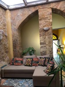 un divano in una stanza con un muro di pietra di Experience Museum a Agrigento