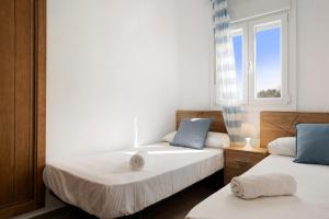 two beds in a room with a window at Villa Montemedio - Paco in El Soto +18 photos