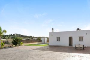a white house with a patio with two tables at Villa Montenmedio - Paula in El Soto