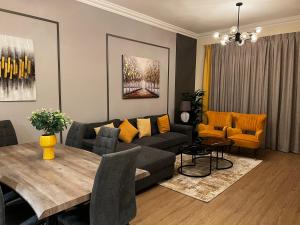 GOODWOOD SUITES HOMES VACATION في دبي: غرفة معيشة مع أريكة وطاولة