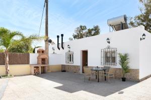 a patio with a table and chairs in front of a building at Villa Montenmedio 1 in El Soto