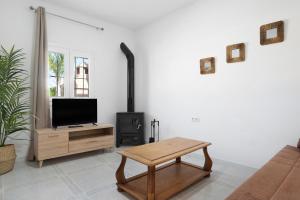a living room with a tv and a wood stove at Villa Montenmedio 1 in El Soto