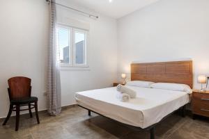 a bedroom with a bed and a chair and a window at Villa Montenmedio - Juande in El Soto +18 photos