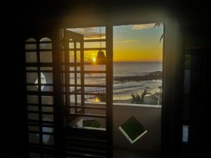 a window with a view of the ocean and the sunset at Villa One64 Beach Front - Apartments in Hikkaduwa