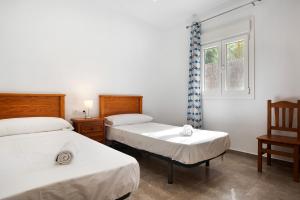 una camera da letto con due letti e una finestra di Villa Montenmedio - Carmelo a El Soto Altre 15 foto