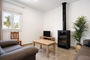 un soggiorno con divano e stufa a legna. di Villa Montenmedio - Carmelo a El Soto