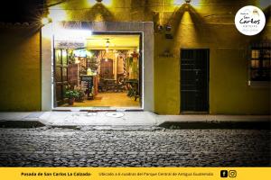 an open door of a store in a street at night at Posada de San Carlos La Calzada in Antigua Guatemala