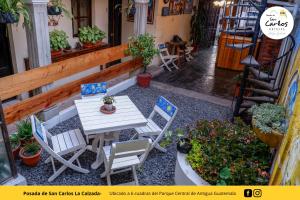 un patio con mesa, sillas y plantas en Posada de San Carlos La Calzada, en Antigua Guatemala