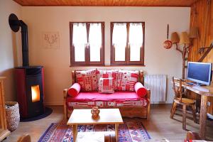 sala de estar con sofá y estufa de leña en Petit chalet de montagne avec espace extérieur en Labaroche