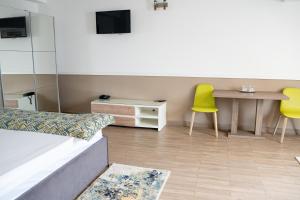 a living room with a table and two yellow chairs at Hotel Mariko Inn in Roman