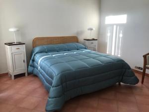 a bedroom with a blue bed with two night stands at Casa di Luca in Viareggio