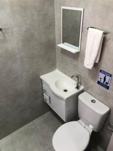 uma casa de banho com um WC, um lavatório e um espelho. em Pousada HD em Nova Friburgo