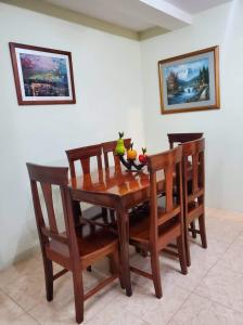 - une table en bois avec des chaises et une corbeille de fruits dans l'établissement Departamento Puyo Fantastic., à Puyo
