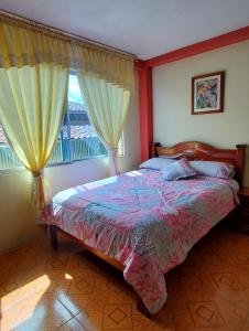 a bedroom with a bed and a window at Departamento Puyo Fantastic. in Puyo