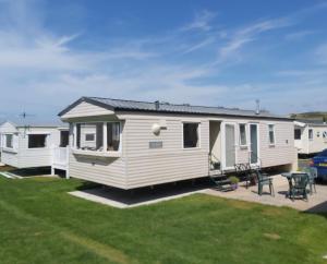 a white caravan parked in a lot with a yard at Clwyd 40 Vacation in Borth