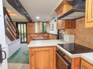 a kitchen with wooden cabinets and a stove top oven at Park Cottage in Ambleside