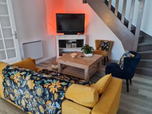 a living room with a couch and a tv at Maison de Campagne cosy in Pons