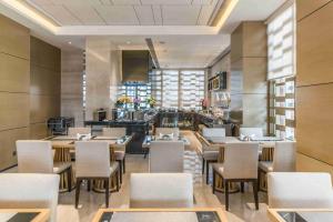 a restaurant with tables and chairs in a room at Somerset Grandview Shenzhen in Shenzhen