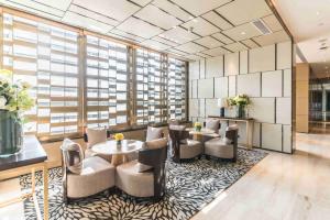 a lobby with a table and chairs and a large window at Somerset Grandview Shenzhen in Shenzhen